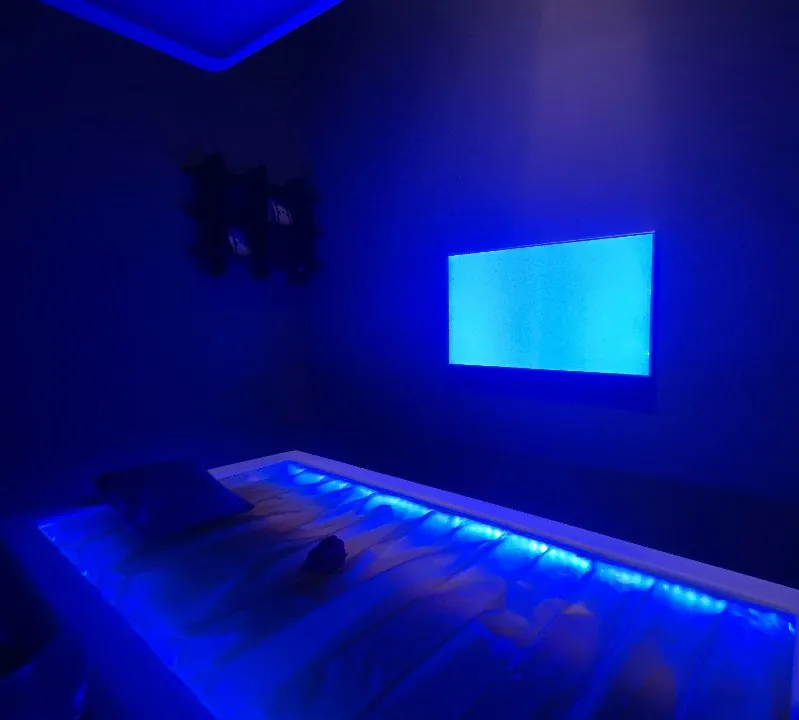Cabina massaggi con luce blu soffusa e lettino ad acqua