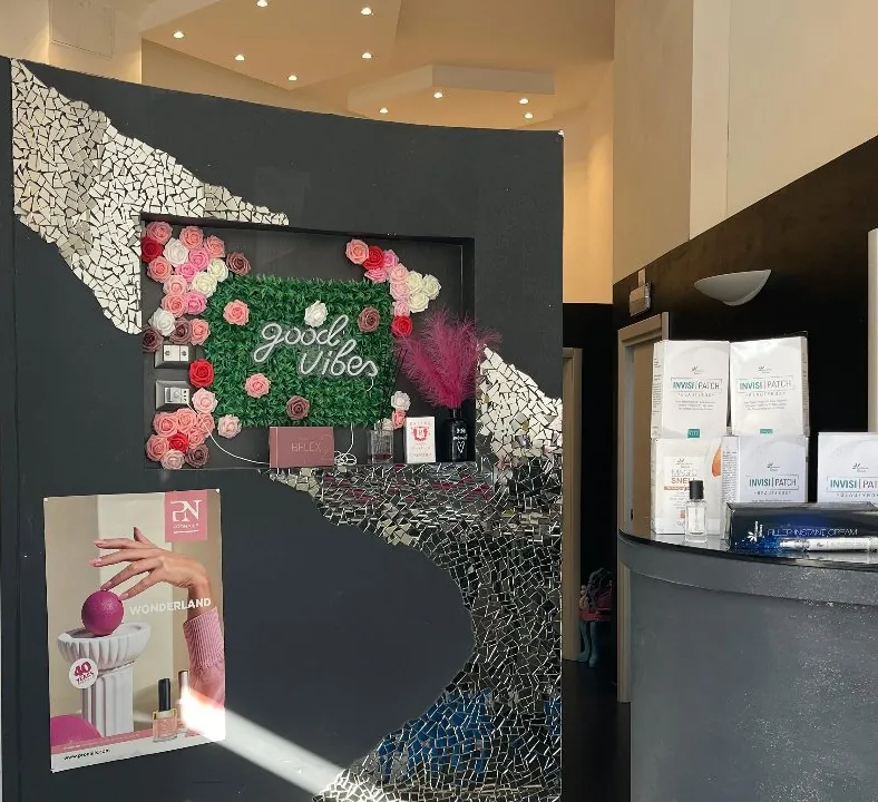 L'ingresso con la parete good vibes di rose, il mosaico a specchi e il bancone